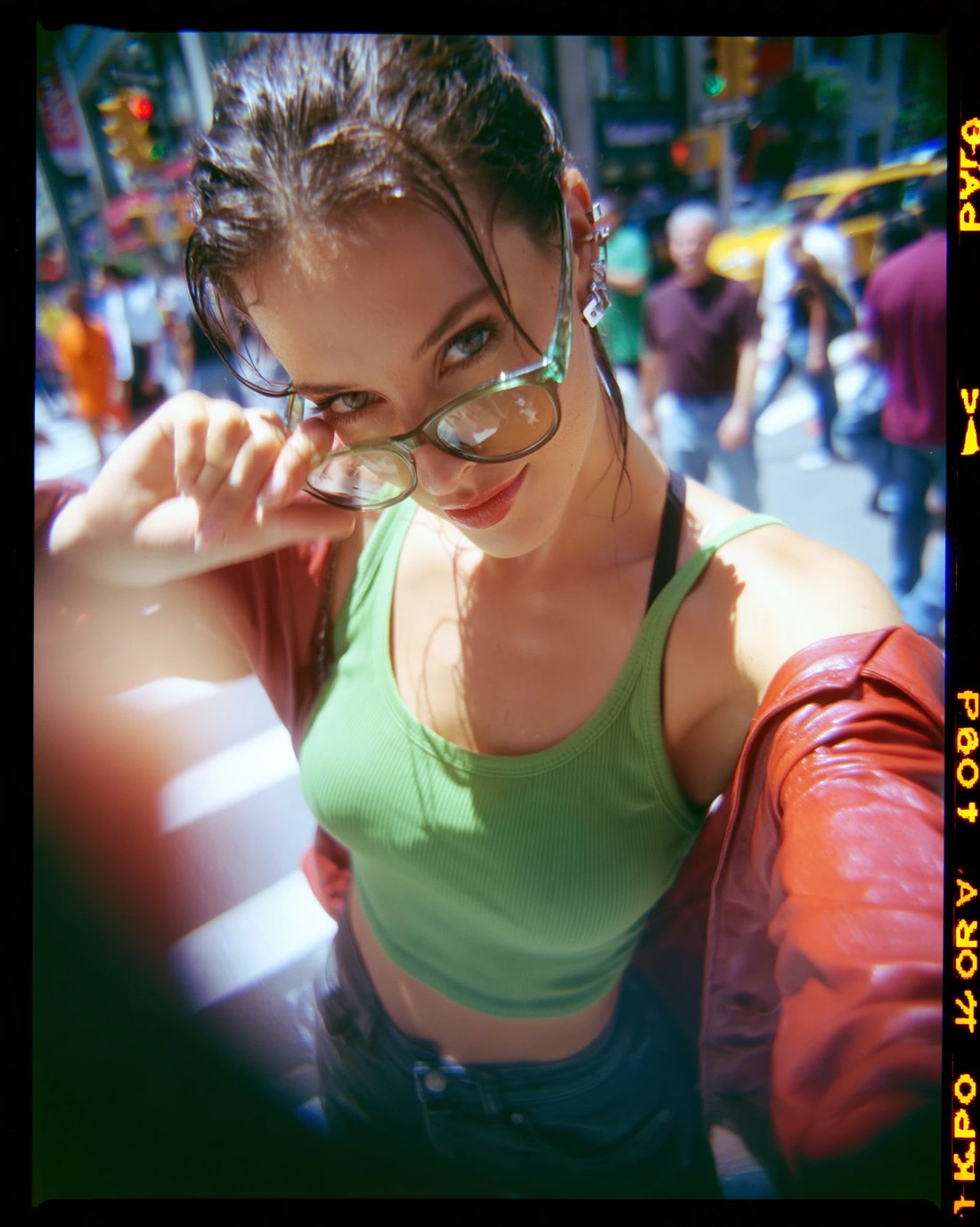 Film frame, wet hair and green tank on a city crossing